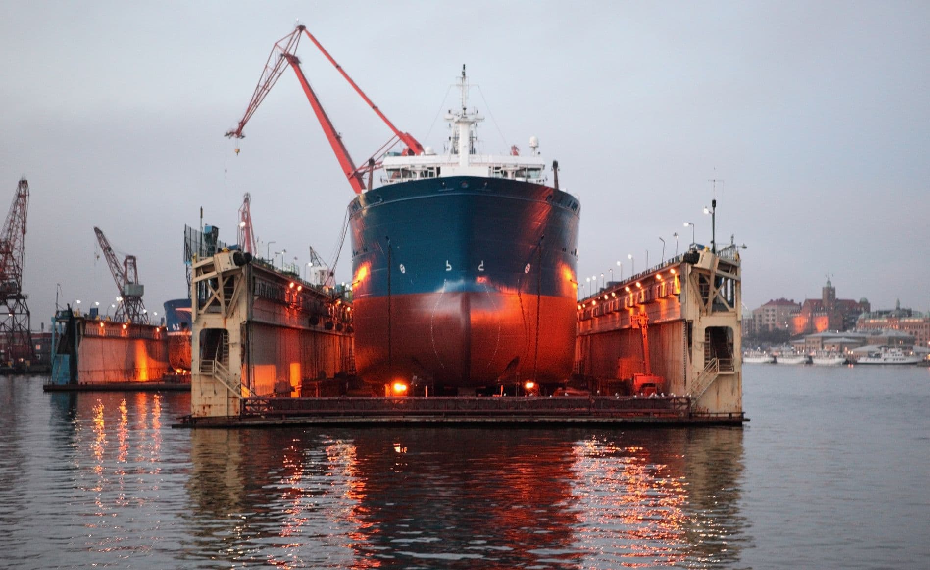 A ship in a floating drydock at dusk